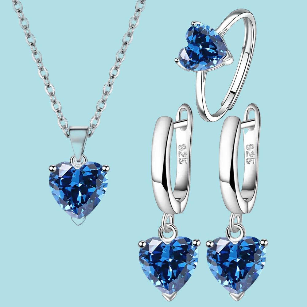 Jewelry set with heart-shaped blue gemstones on a blue background