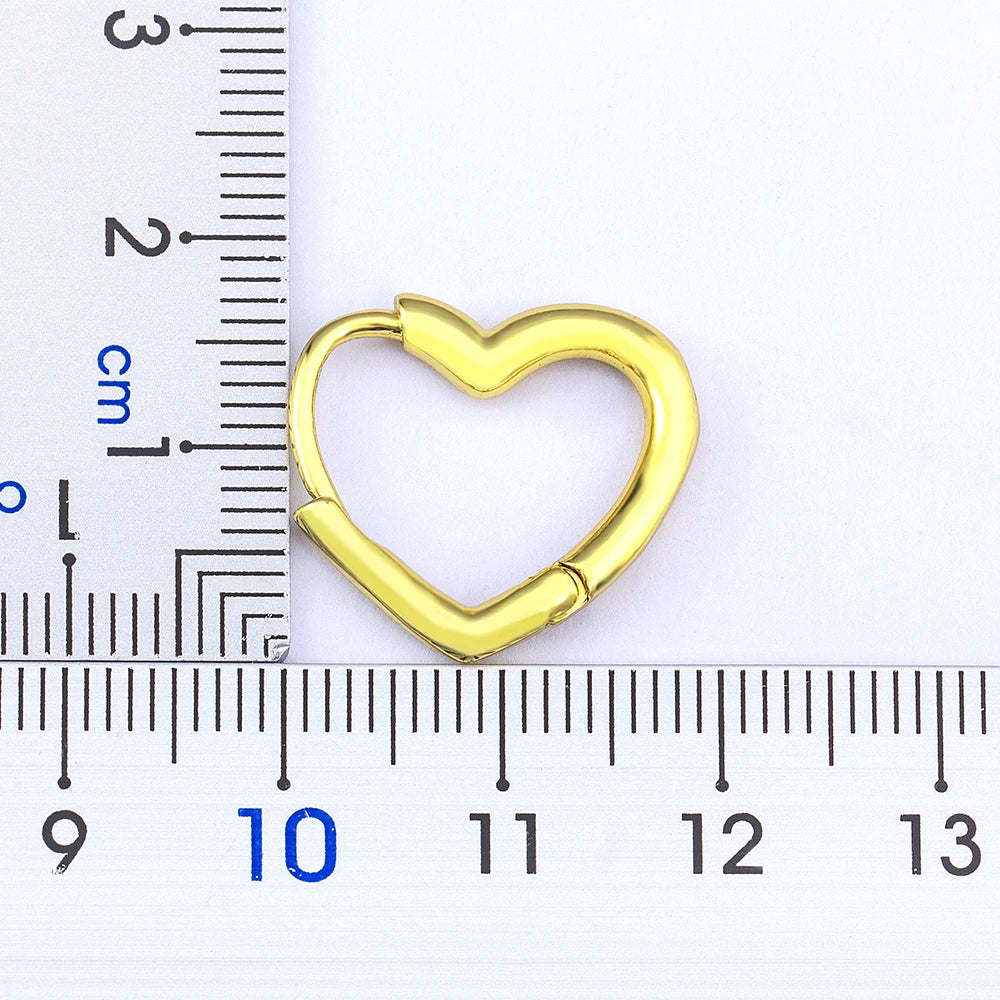 Gold heart-shaped keyring with a ruler for scale on a white background