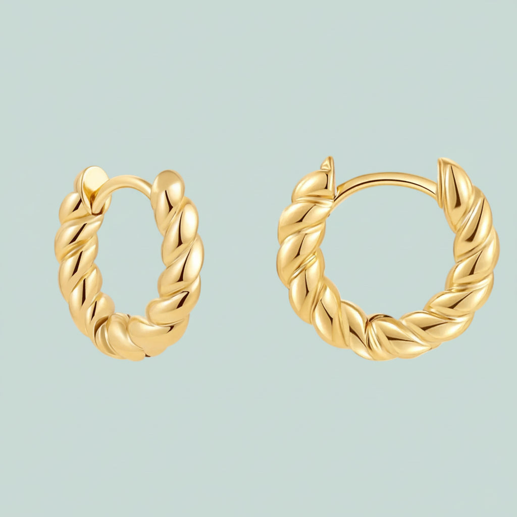Pair of gold hoop earrings on a light blue background