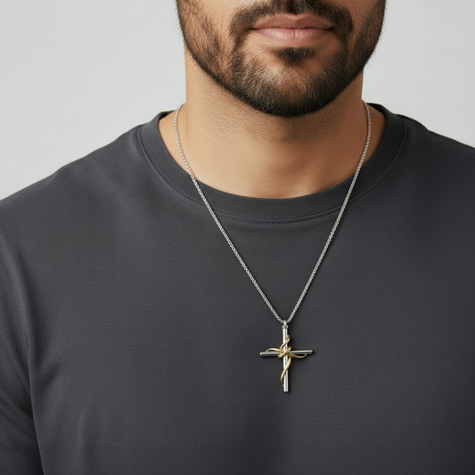 Man wearing a dark gray shirt with a necklace featuring a cross pendant.
