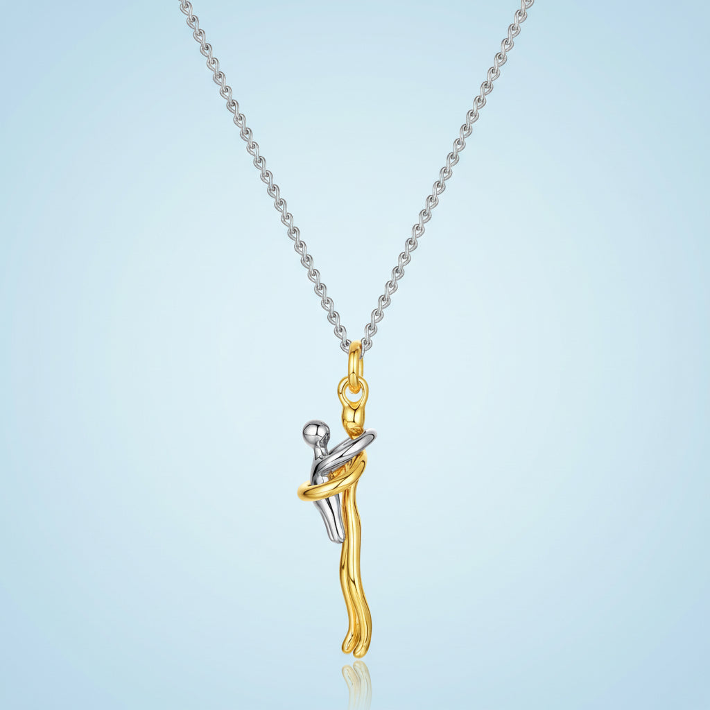 Gold and silver pendant on a chain against a light blue background