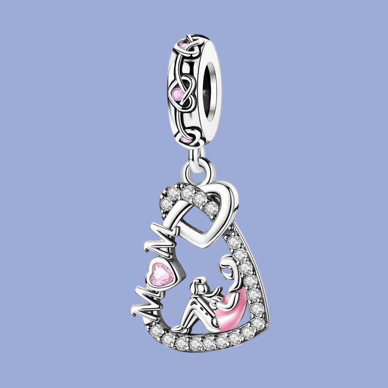Silver charm with 'MOM' and heart design on a blue background