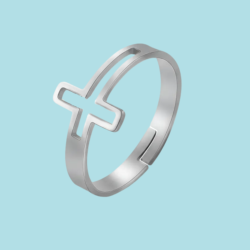 Silver ring with a cross design on a light blue background