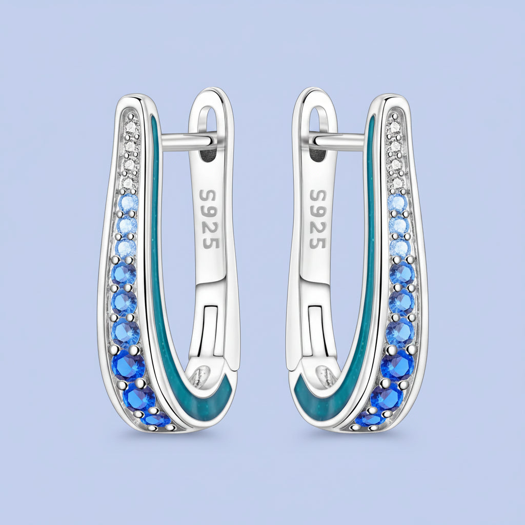 Silver hoop earrings with blue gemstones on a white background