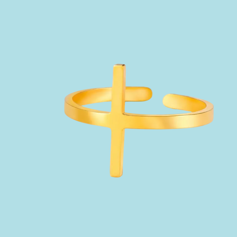 Gold open ring with a cross design on a light blue background