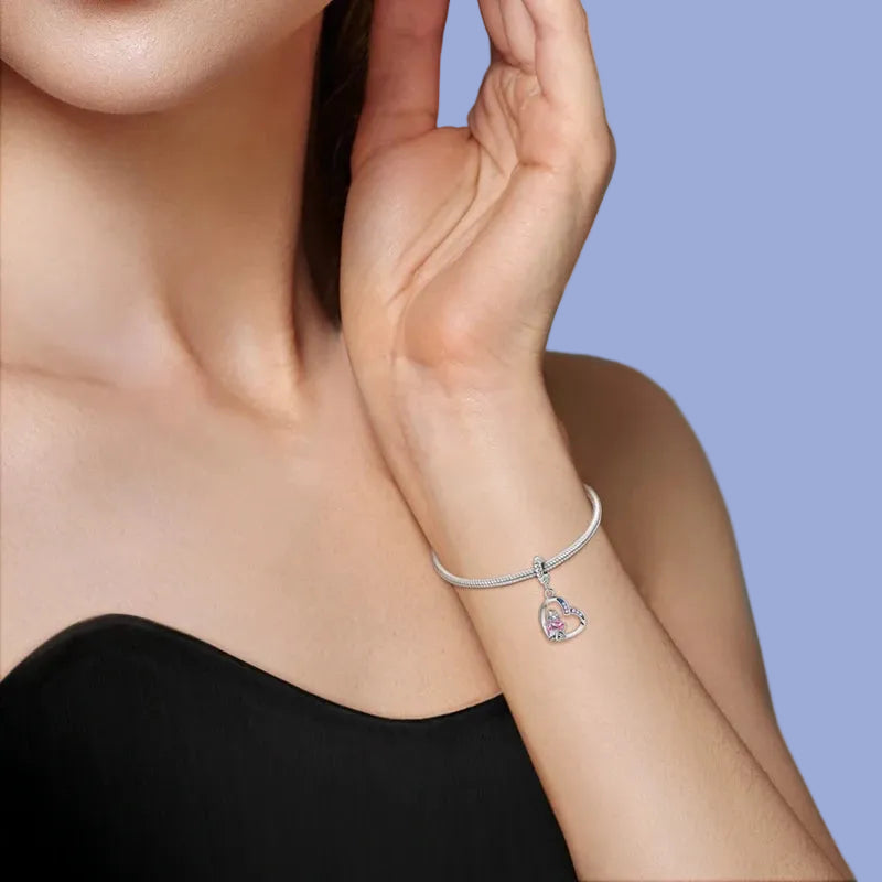 Woman wearing a silver bracelet with a clear gemstone on a light background