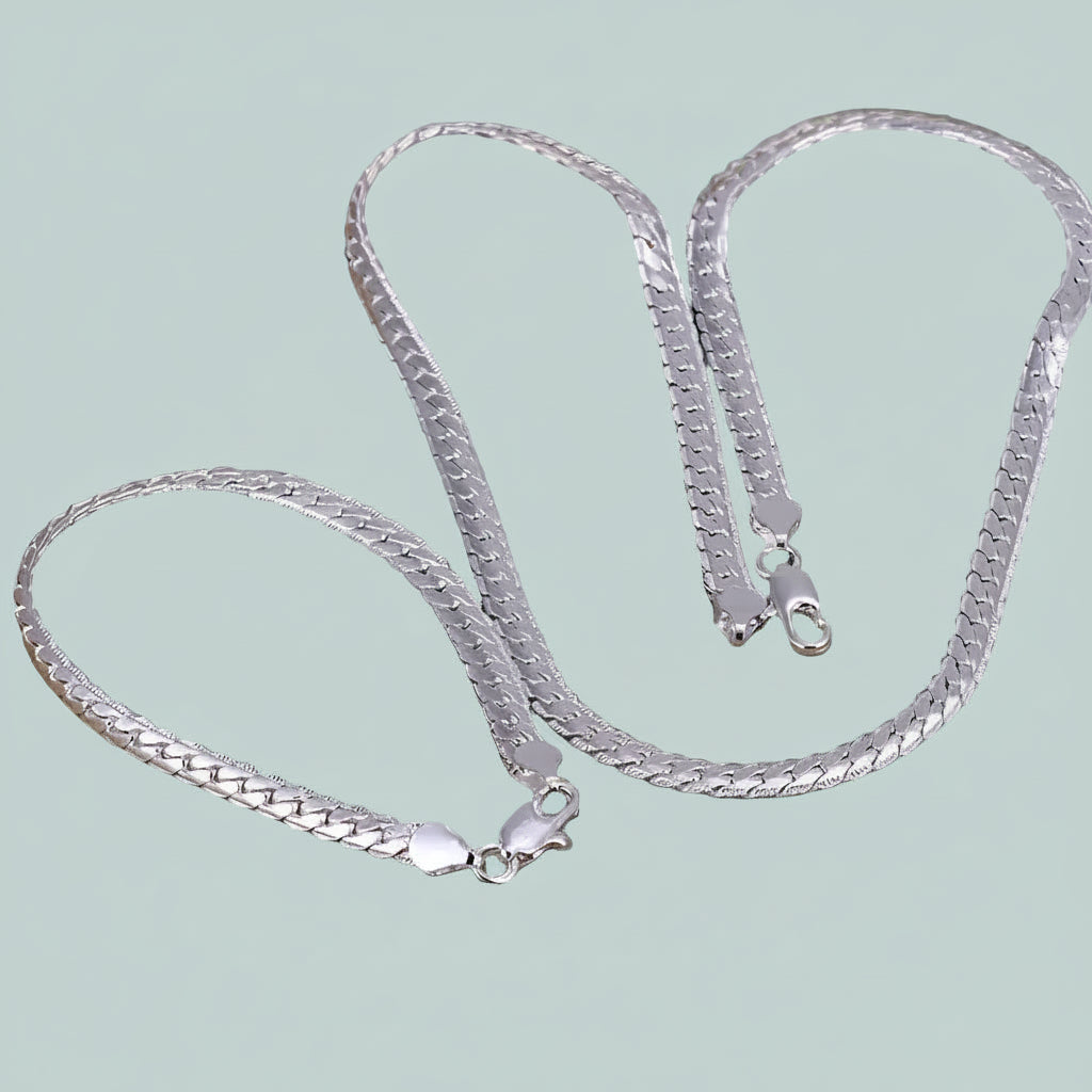 Silver chain necklace on a light light blue background.