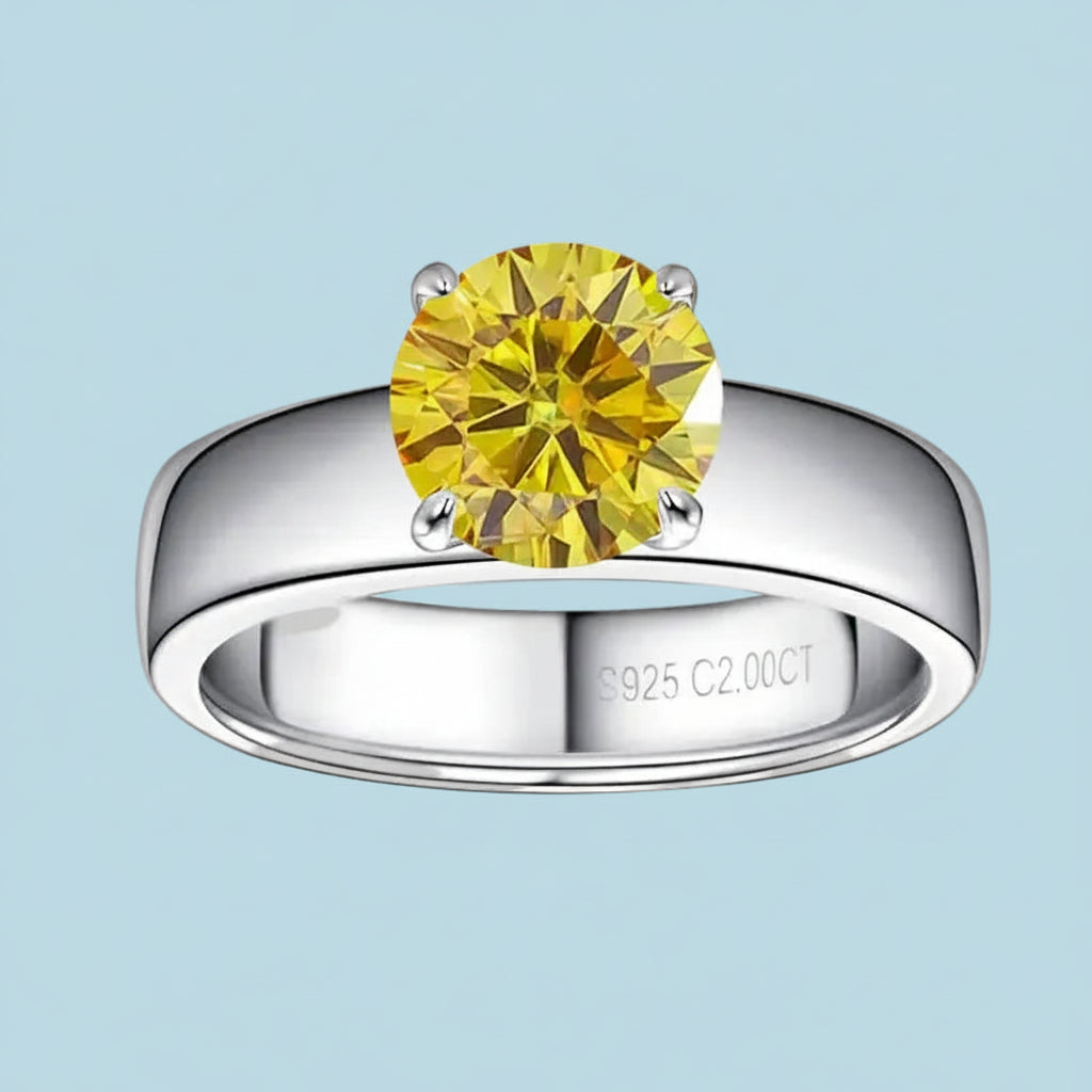 Silver ring with a yellow gemstone on a light blue background