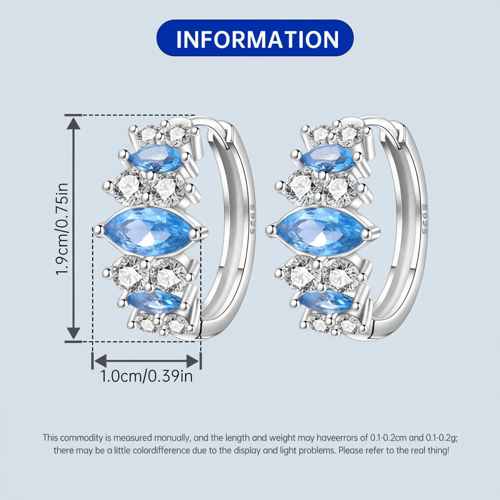Pair of hoop earrings with blue gemstones and clear stones, showing measurements on a light blue. background.