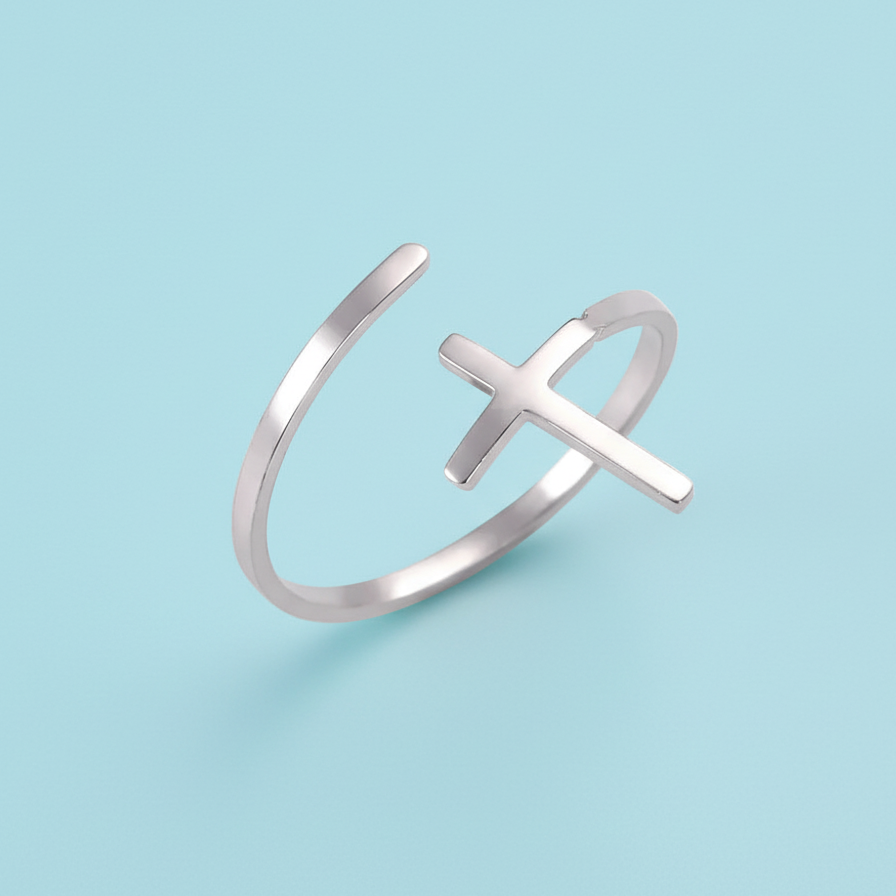 Silver ring with a cross design on a light blue background