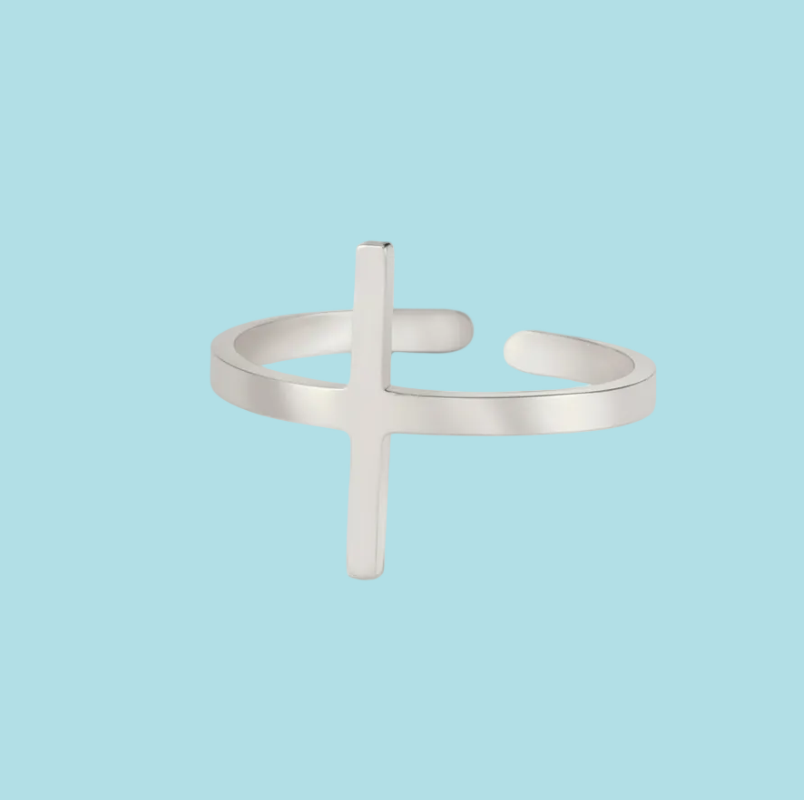 Silver ring with a cross design on a light blue background