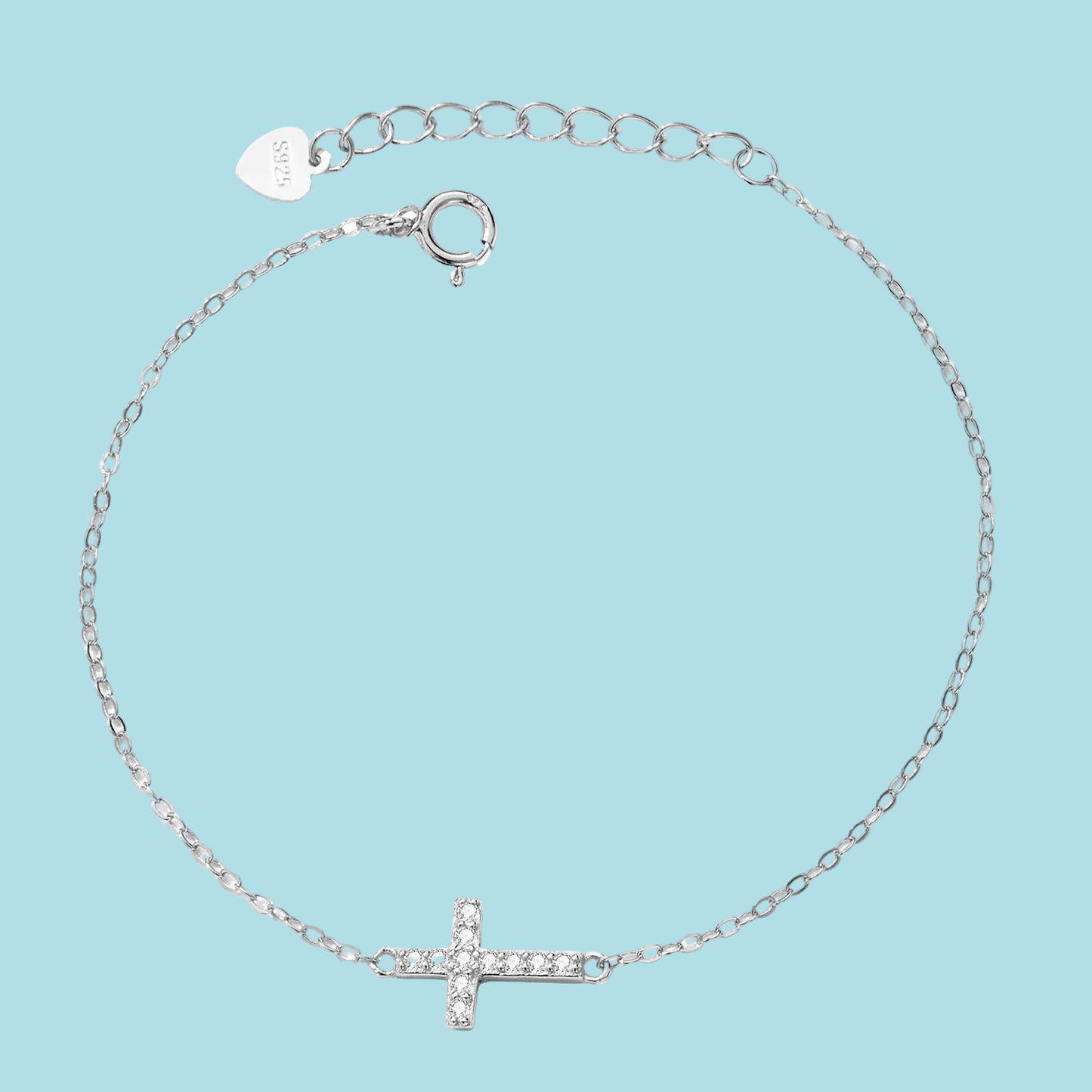 Silver bracelet with a small cross charm on a blue background