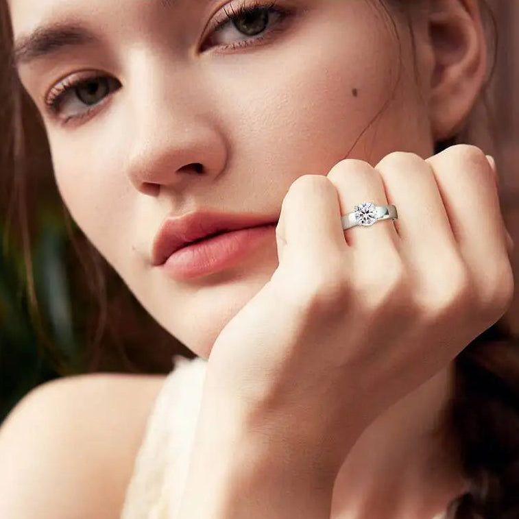 Close-up of a woman wearing a silver ring with a diamond on a blurred background