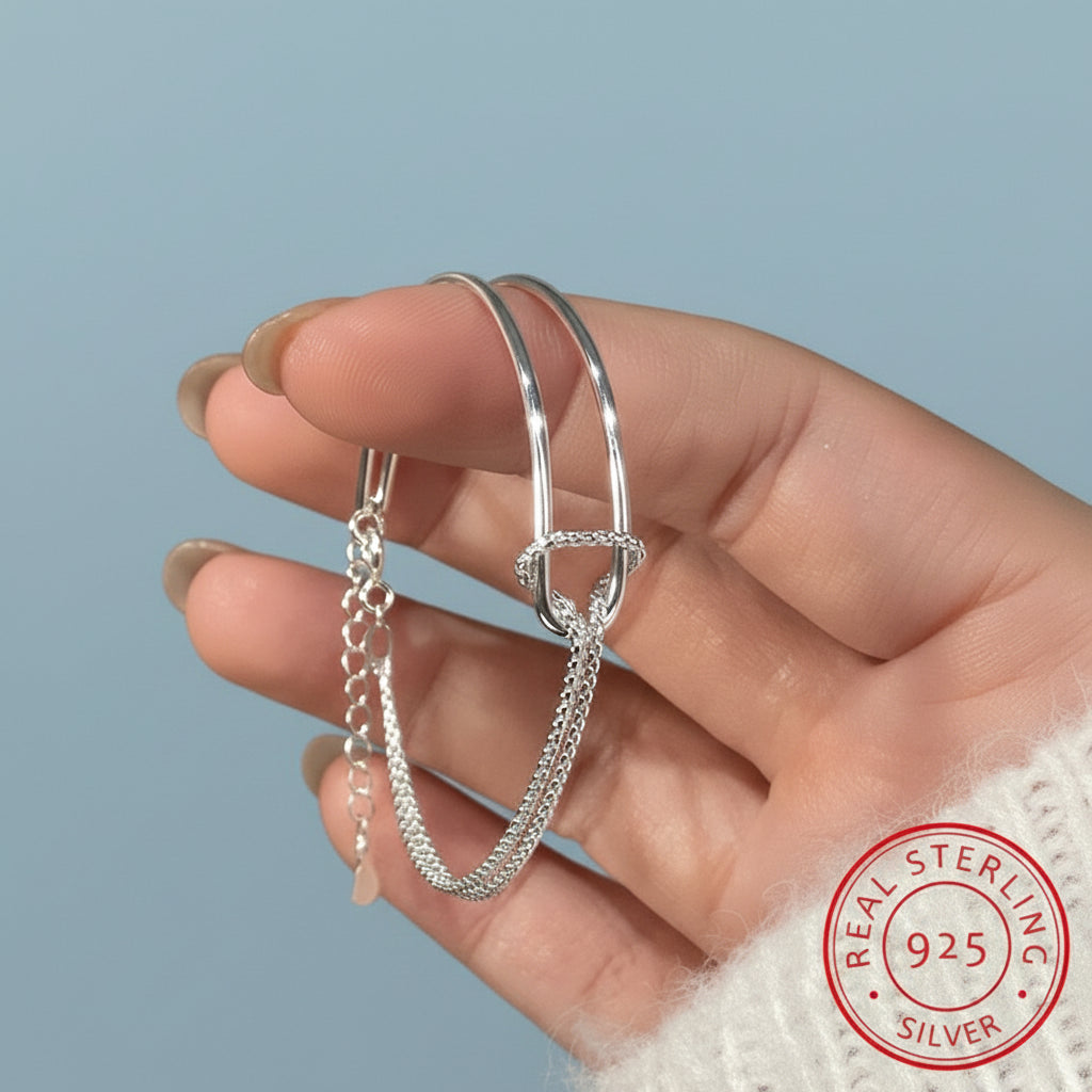 Hand holding two silver bangles with and a 'Real Sterling Silver 925' stamp.