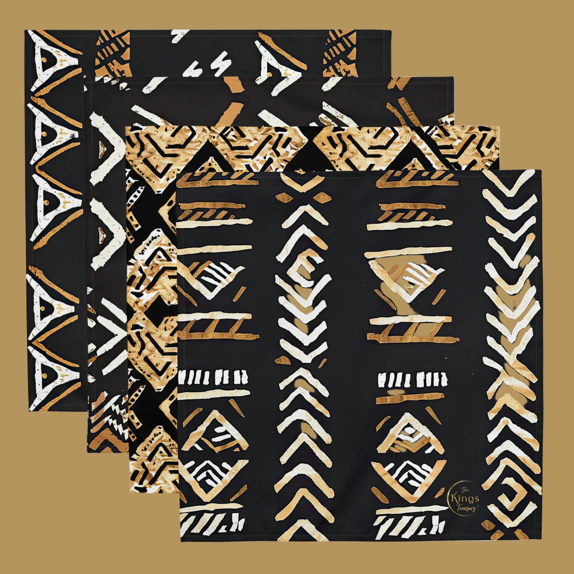 Four square black napkins with overlapping geometric tribal patterns in white and tan, displayed on a clean white background.