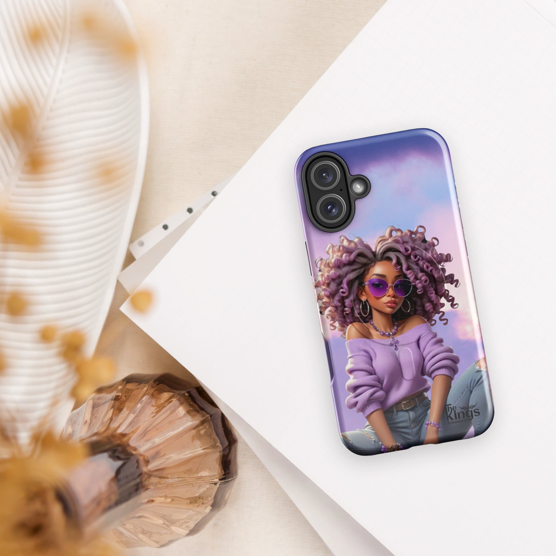Phone case with a colorful design of a woman with an afro on a white surface.