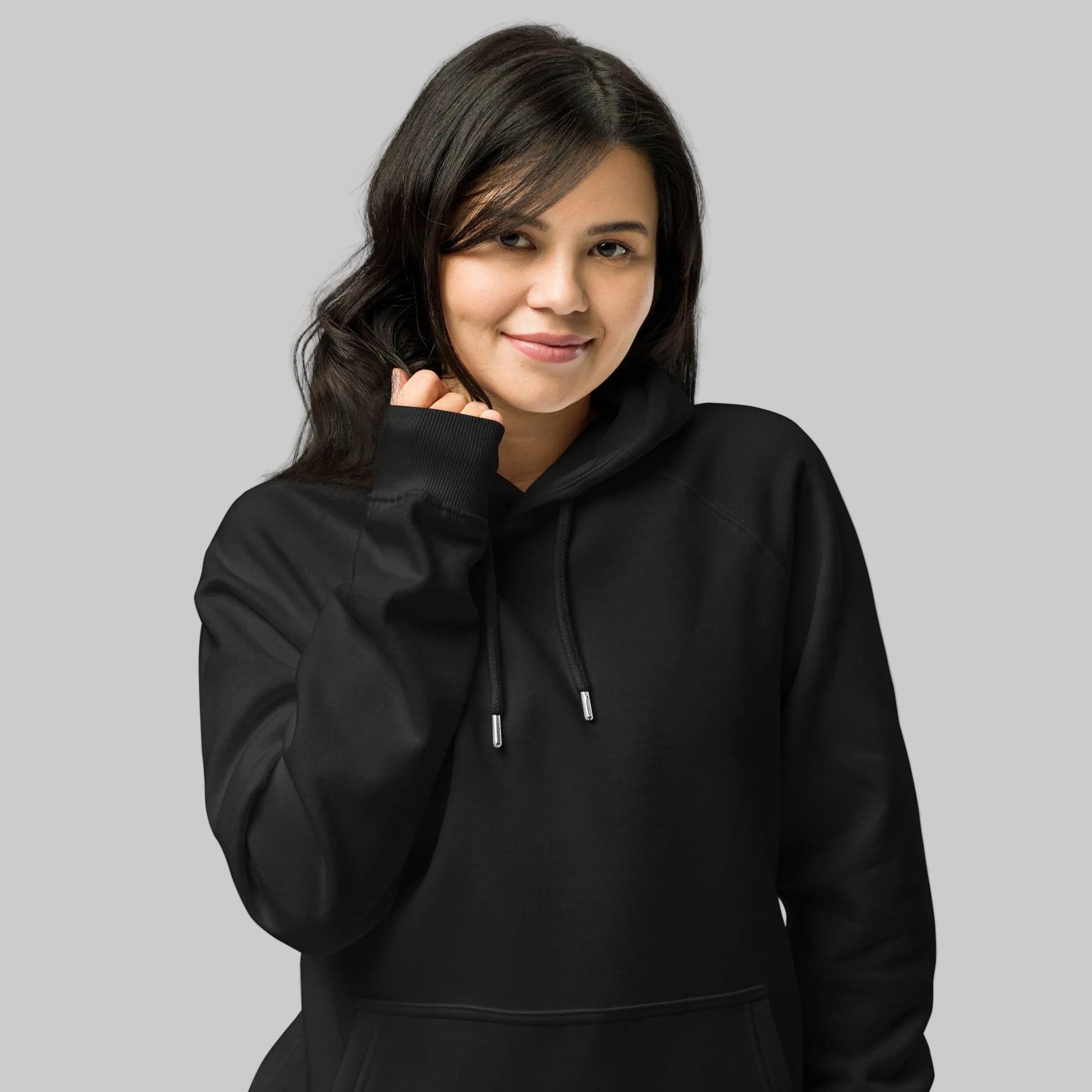 Person wearing a black hoodie against a gray background