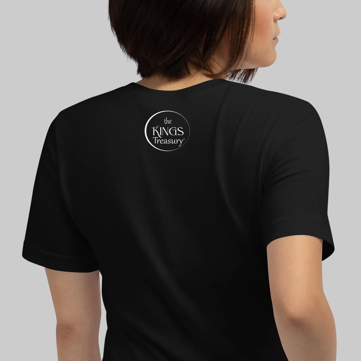 the back of black "Woke" t-shirt with a circled "The Kings Treasury" logo